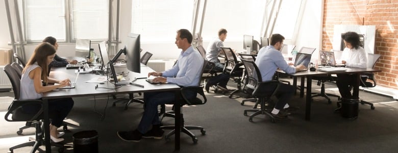 diverse-workers-sitting-at-desk-working-in-coworking-space-picture-id1124783373