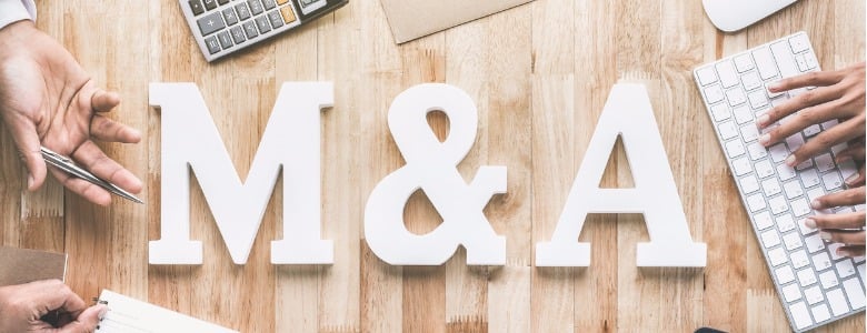 top-view-of-business-office-workstation-with-ma-letters-or-merger-and-picture-id876353660